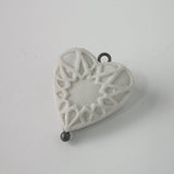 Small porcelain heart with star pattern and silver eye.